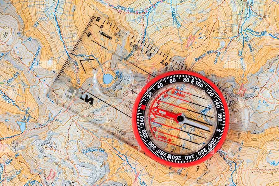 Brujula cartográfica sobre un mapa topográfico